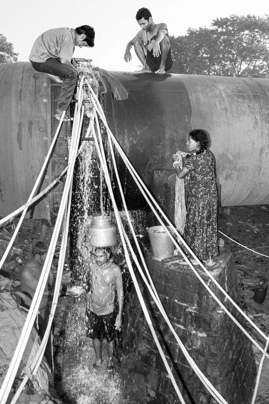 Human Right to Water in Mumbai - A pipeline leakage serving as a water source for neighboring unserved slums